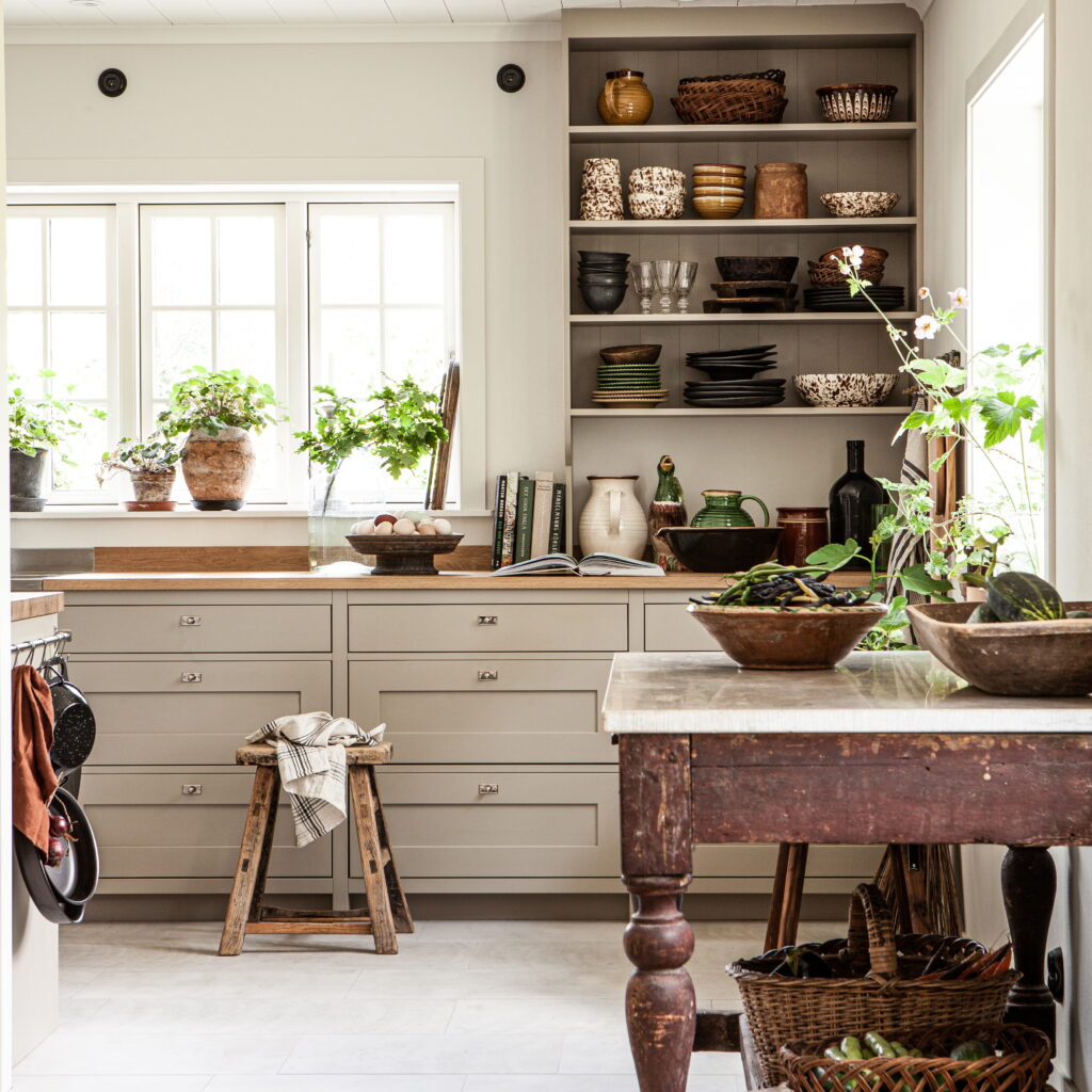 Köksvägg med öppna hyllor och fönster