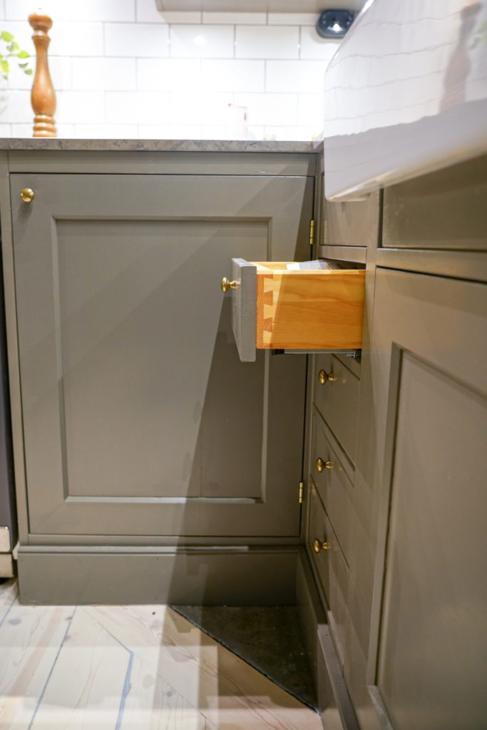 Utdragen kökslåda i grått underskåp