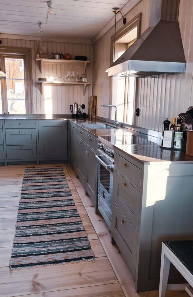 Gråblått kök i massiv furu med lång bänkrad