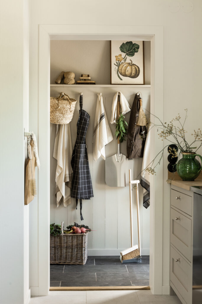 Vägg med krokar och förvaring i lantkök