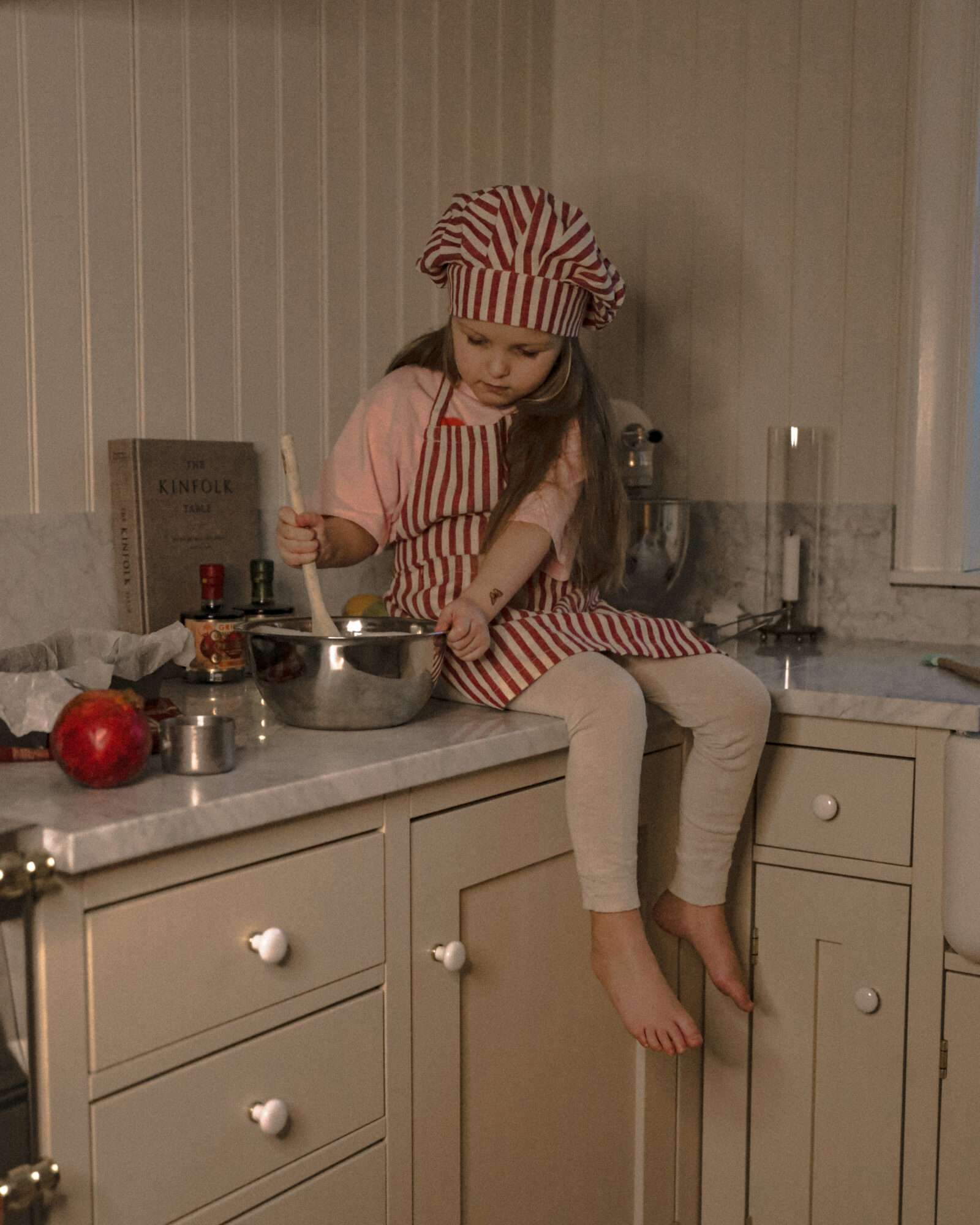 Barn sitter på köksbänk i ljust kök