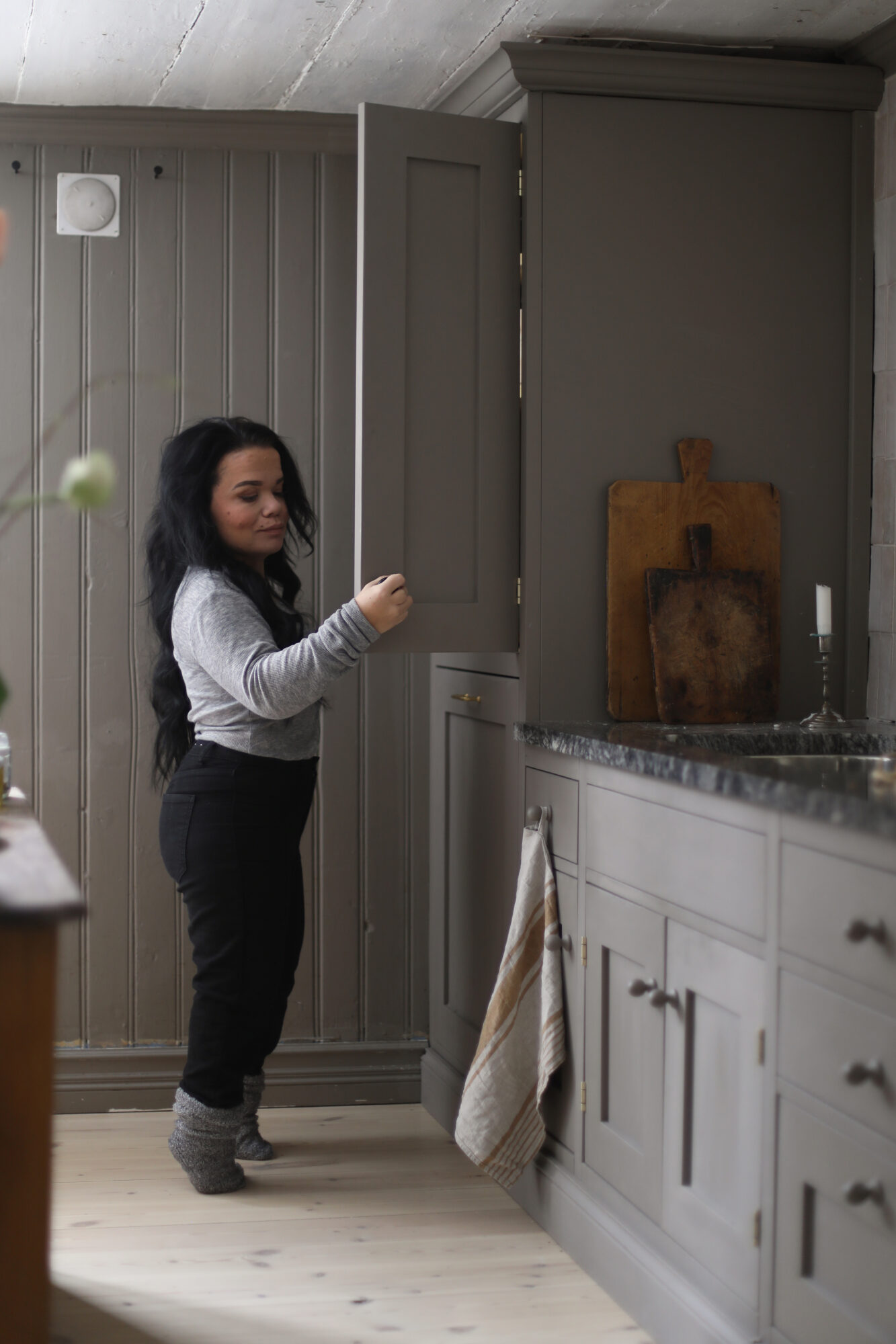 Person vid köksbänk med kaklad vägg