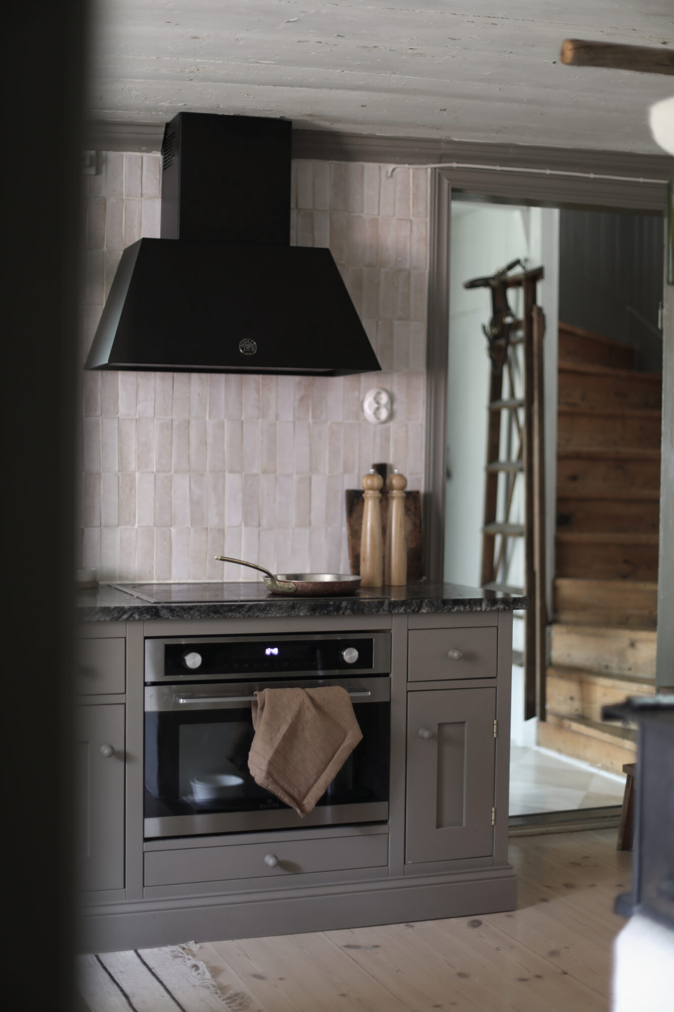 Spis med svart fläktkåpa och kaklad vägg