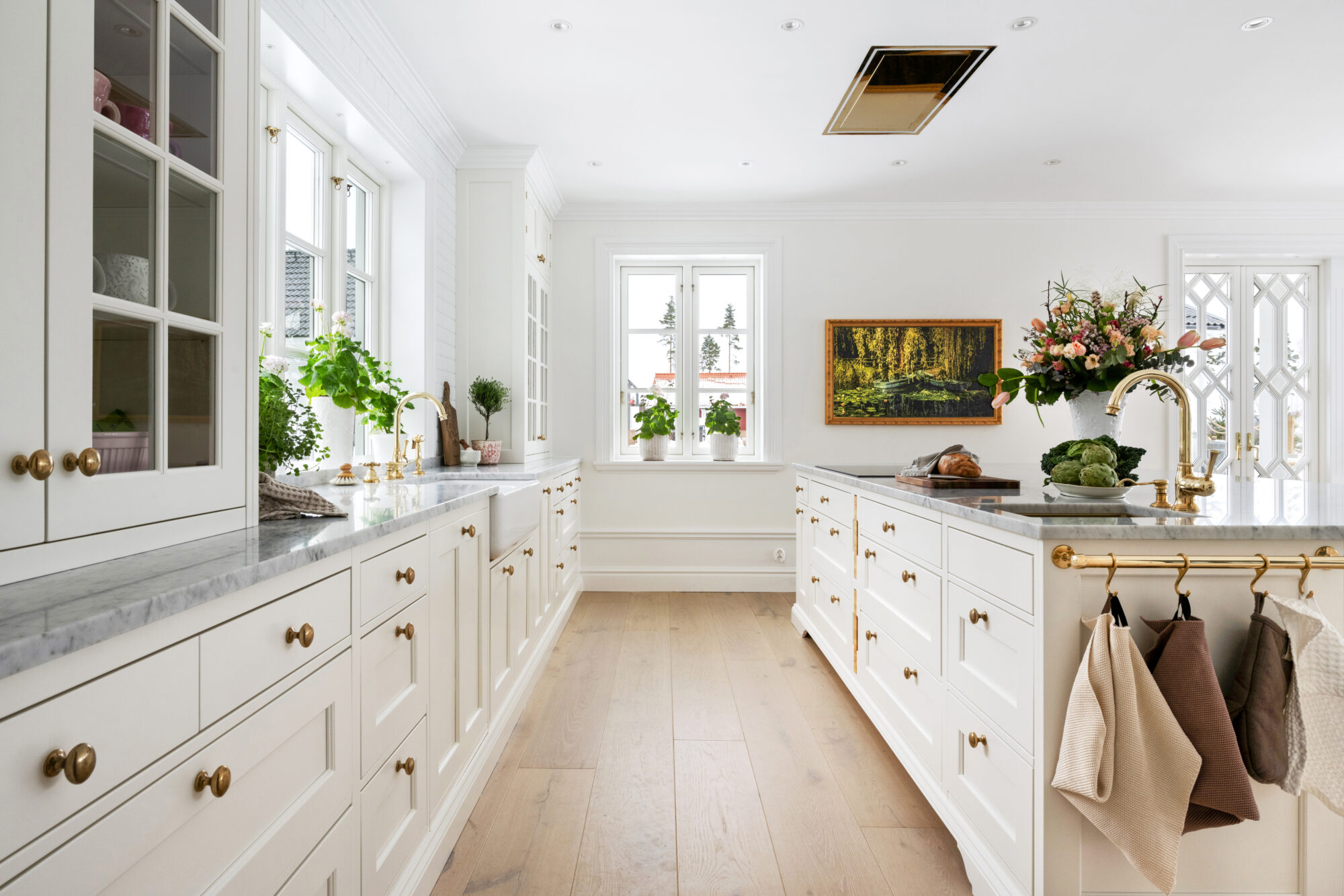 Lång bänkrad i vitt kök med fönsterljus