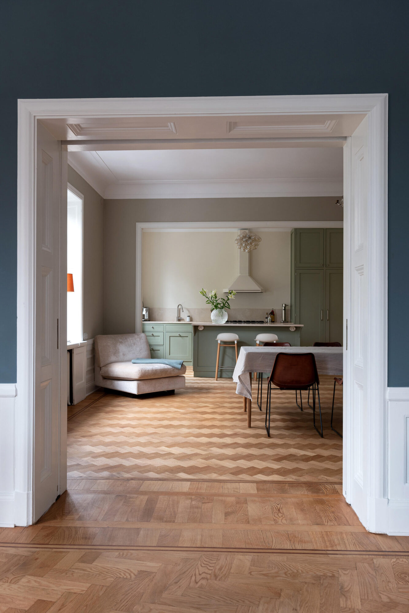 Passage mot kök med köksö i grön kulör