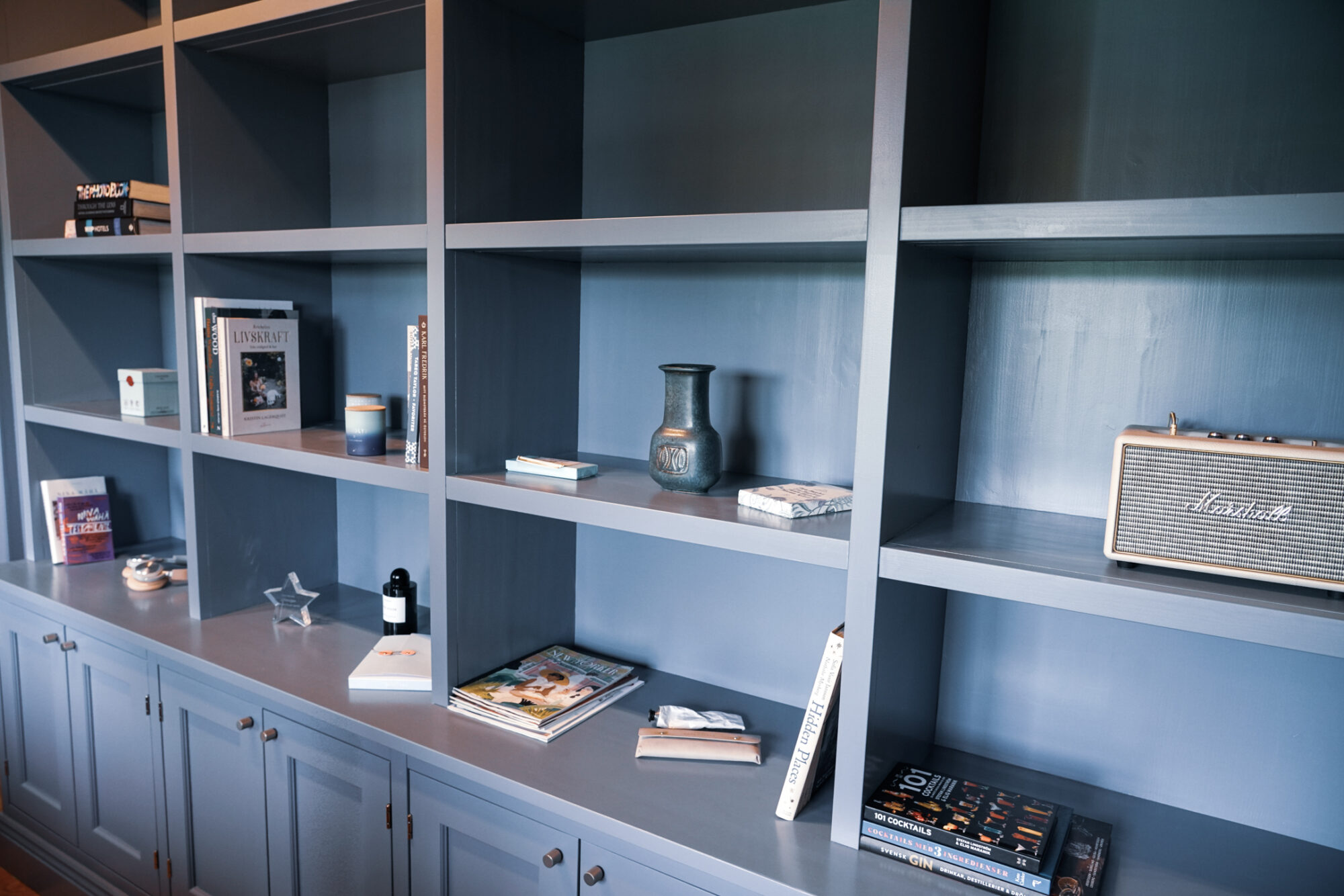 Blå bokhylla med öppna fack och underskåp