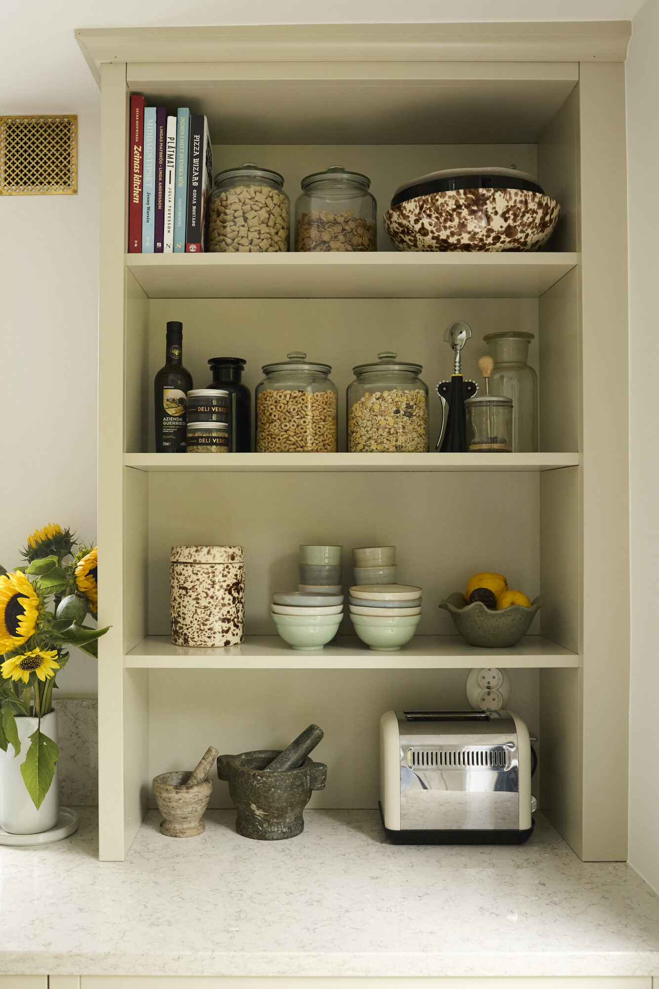 Öppen hylla med burkar och porslin i kök