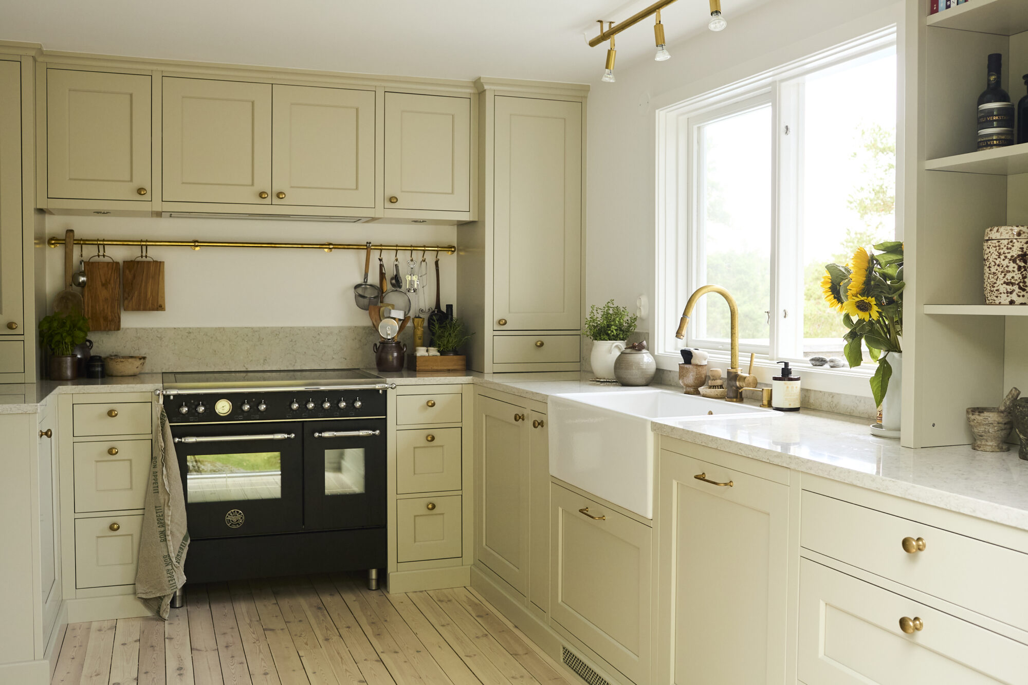 Diskbänk och spis i ljust kök med fönster