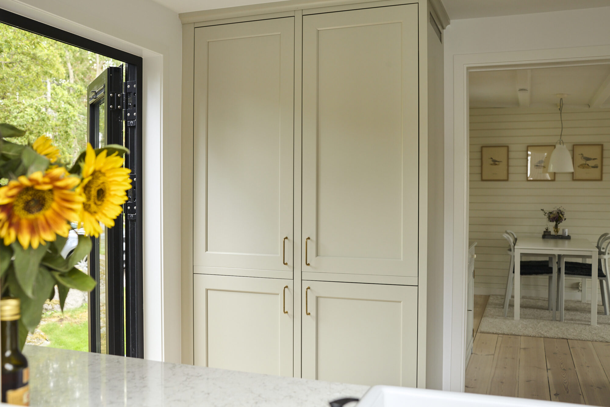 Högskåp i ljust kök med spegelluckor